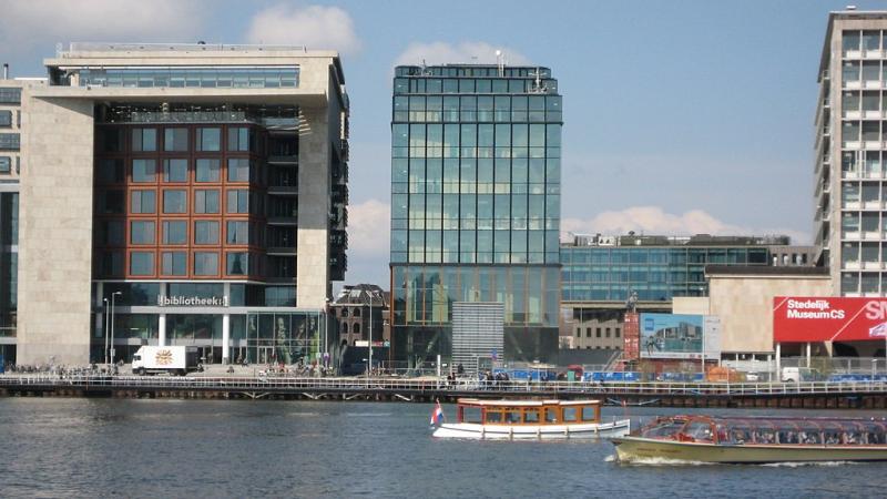 View of Amsterdam School of Music from across the river with boats in it