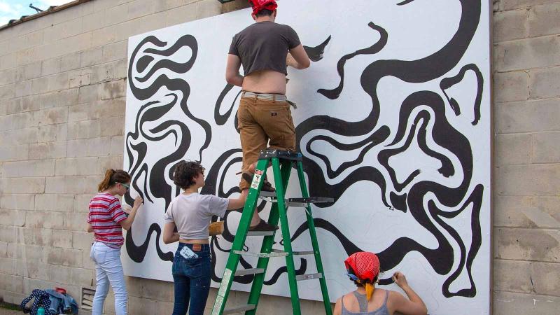 Image of people painting a black and white mural