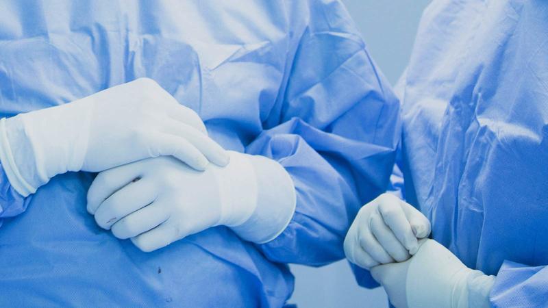 Medical professionals wearing gloves and scrubs