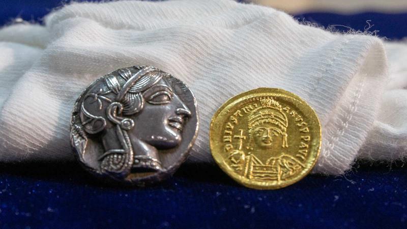 Ancient coins on top of white gloves
