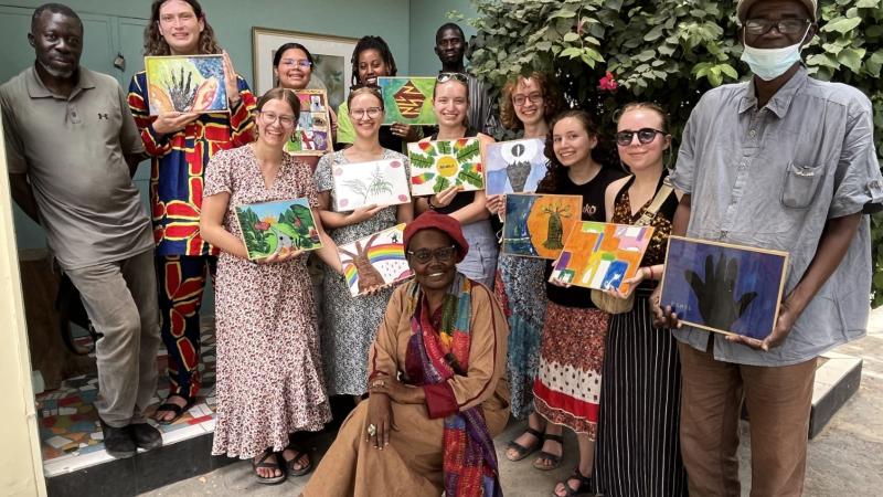 Students in Senegal holding paintings