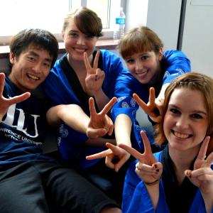 Four students smiling with peace signs 